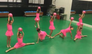 foto del equipo de gimnasia rítmica del colegio Santo Ángel realizando una de sus actuaciones en una competición en un gimnasio