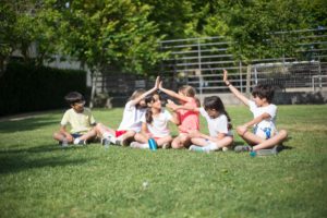 niños en un césped hablando contentos 