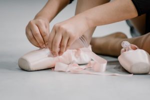 imagen de una niña poniéndose las puntas de ballet en la escuela de música y artes escénicas del colegio SABS